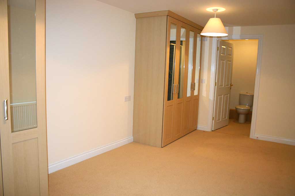 bedroom with fitted cupboards and en-suite